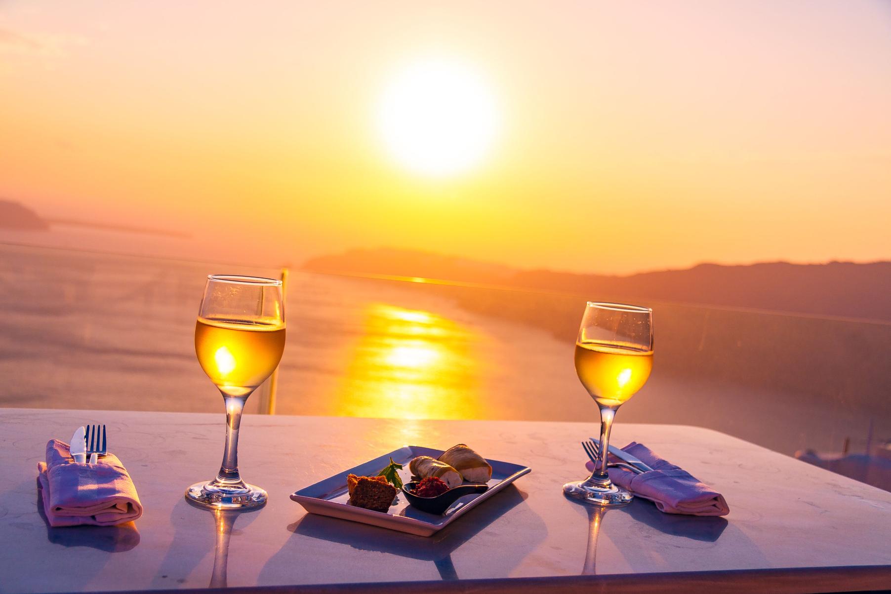 couple enjoying romantic dinner with Santorini sunset view