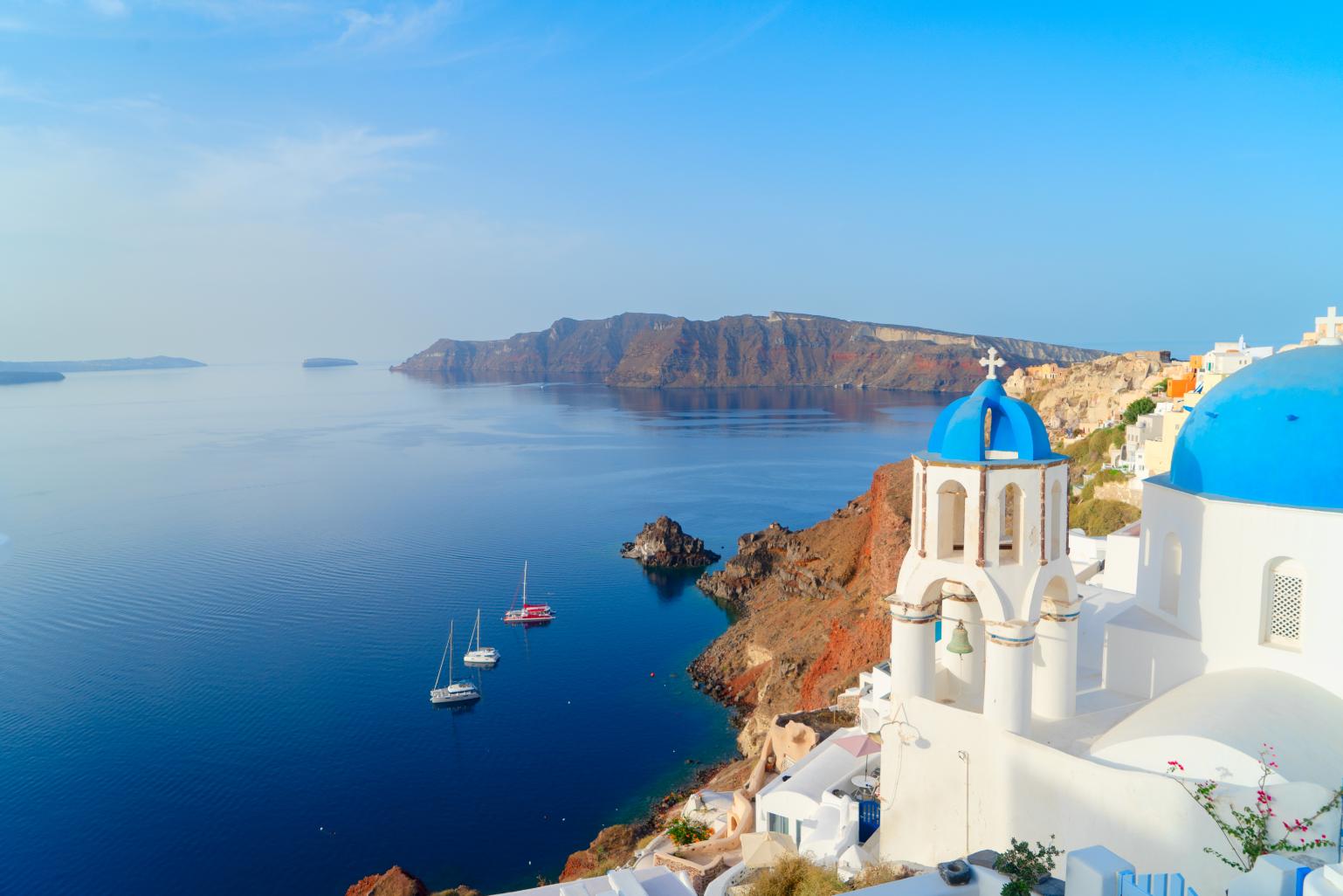 couple walking through Santorini whitewashed street 